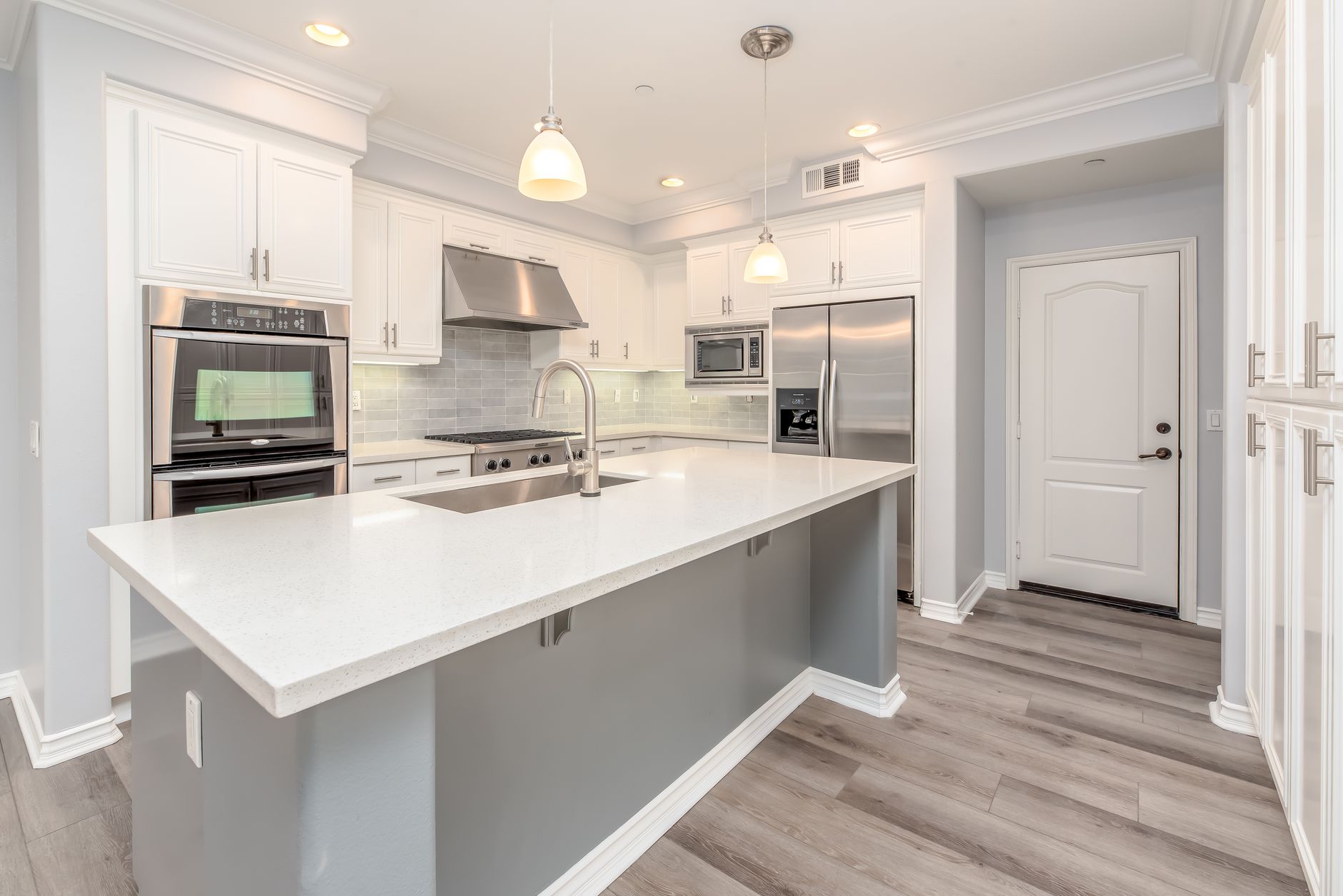Modern kitchen interior featuring sleek white cabinetry and stainless steel appliances in Irvine, CA